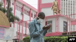 Un homme portant un masque marche devant l'entrée de l'hôpital général de Yaoundé, le 6 mars 2020 alors que le Cameroun a confirmé son premier cas de COVID-19. (Photo par - / AFP)
