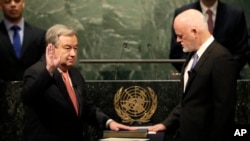 Antonio Guterres, à gauche, prête serment comme secrétaire général de l’ONU face au Président de l'Assemblée générale, Peter Thomson, au siège de l'ONU à New York, le 12 décembre 2016.