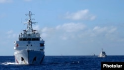 FILE - Chinese ships guard the Haiyang Shiyou oil rig in the South China Sea, July 15, 2014.
