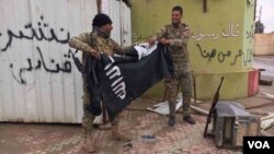 Dua tentara Irak merobek bendera ISIS di Mosul, Irak (foto: ilustrasi). Kelompok ekstremis ISIS terus kehilangan wilayah kekuasaannya di Irak dan Suriah. 