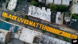 FILE - A giant "Black Lives Matter" sign is painted on Fulton Street, in the Brooklyn borough of New York City, June 15, 2020. 