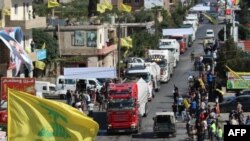 Bendera Hezbollah berkibar menyambut kedatangan tanker yang membawa minyak Iran di al-Ain, Hermel, di Lembah Bekaa, Lebanon timur 16 September 2021. (AFP)