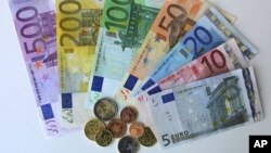 German Euro notes and coins pictured in the regional central bank in Bremen, northwest Germany, Friday, Dec. 14, 2001. On Monday, Dec. 17, the first Euro coins starter kits will start selling all over Germany. The Euro will appear as 5, 10, 20, 50, 10O, 2