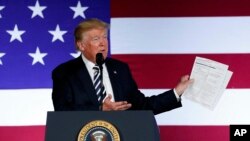 도널드 트럼프 미국 대통령이 지난달 31일 노스케롤라이나주 샬럿에서 연설하면서 집권 후 행정부가 거둔 성과를 나열한 목록을 들어보이고 있다.