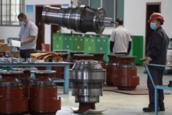 A worker wearing a mask against coronavirus moves gearboxes at the Kofon factory in Huanggang in central China's Hubei province, April 13, 2020.