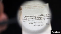 A note written on a Tokyo hotel official paper in 1922 by Albert Einstein is seen before it is sold at an auction in Jerusalem, October 24, 2017. (REUTERS/Ammar Awad)