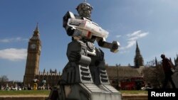 Sebuah tiruan robot pembunuh di depan Parlement Inggris dan Westminster Abbey sebagai bagian kampanye 'Campaign to Stop Killer Robots di London, 23 April 2013.