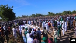 People attend a funeral for those killed by suspected Boko Haram militants in Zaabarmar, Nigeria, Sunday, Nov. 29, 2020. Nigerian officials say suspected members of the Islamic militant group Boko Haram have killed at least 40 rice farmers and…