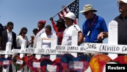 People pray next to a row of crosses representing each of the victims at a growing memorial site two days after a mass shooting at a Walmart store in El Paso, Texas, U.S. August 5, 2019. (REUTERS/Callaghan O'Hare)