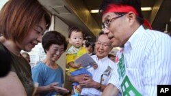 29일 전직 총무상 마스다 히로야 도쿄도지사 후보가 유권자들과 악수하고 있다.