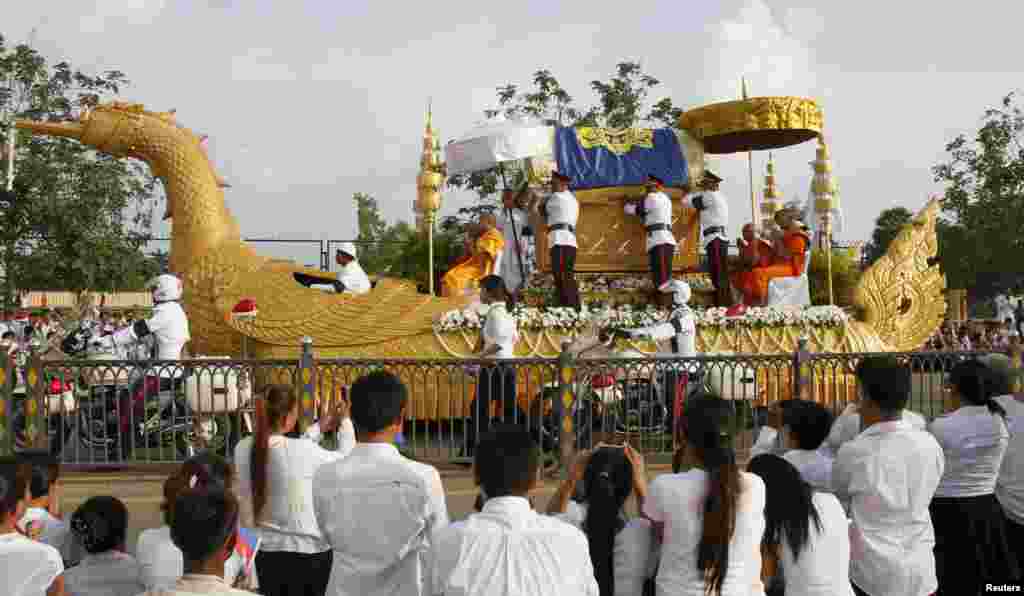 People pray as they see the coffin of former king Norodom Sihanouk on a royal truck along a street in Phnom Penh October 17, 2012.