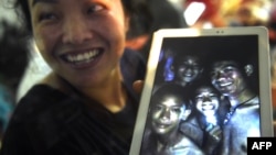 A happy family member shows the latest picture of the missing boys taken by rescue divers inside Tham Luang cave when all members of children's football team and their coach were found alive in the cave at Khun Nam Nang Non Forest Park in the Mae Sai district of Chiang Rai province, Thailand, July 2, 2018.