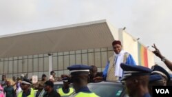 Former President Abdoulaye Wade is escorted out of Dakar international airport, Dakar, Senegal, July 10, 2017. (S. Christensen/VOA)
