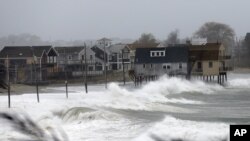 海浪扑向麻萨诸塞州普利茅斯郡一处海滩的房屋(2012年10月29日)。