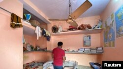 Niranjan Kumar, one of the jobless youth protesting against alleged errors in Indian Railways recruitment, checks out a notebook in his dormitory room in Patna city in the eastern state of Bihar, India, January 29, 2022. 2022. (REUTERS/Krishna N. Das)