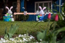 FILE - The owners of a house known for their seasonal decorations have put up a display combining Easter and coronavirus-related social distancing measures in their yard, seen April 1, 2020, in Washington, D.C.