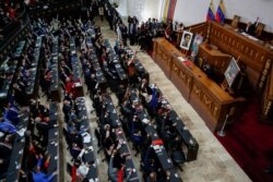 People raise their hands during the swear-in ceremony of Venezuela's National Assembly new term, in Caracas, Venezuela, Jan. 5, 2021.