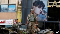 FILE - Lebanese army soldiers on their armored vehicle stand guard in Beirut, Oct. 15, 2021, at the site where deadly clashes erupted the previous day.