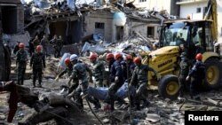 搜救人员将炮击遇难者遗体抬出废墟。阿塞拜疆10月11日称，亚美尼亚军队对占贾发动夜间炮击。（照片来自路透社 REUTERS/Umit Bektas）