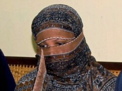 FILE - Asia Bibi, a Pakistani Christian woman, listens to officials at a prison in Sheikhupura near Lahore, Pakistan, Nov. 20, 2020.