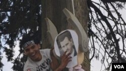 Seorang demonstran anti pemerintah Suriah menggantung patung Presiden Bashar al-Assad (foto: dok).