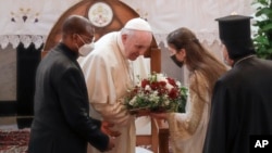 Pope Francis is welcomed upon his arrival at the Sayidat al-Nejat (Our Lady of Salvation) Cathedral, in Baghdad, Iraq, Friday, March 5, 2021. (AP Photo/Andrew Medichini)