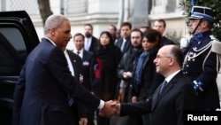 Eric Holder (à g.) à Paris dimanche (AP)