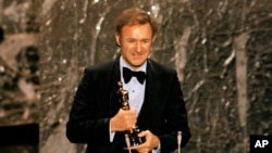 FILE - Gene Hackman accepts his Oscar for best actor at the 44th Academy Awards in Los Angeles, April 10, 1972. 