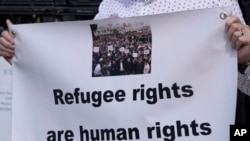 Waandamanaji wakiwa wamesimama nje ya Mahakama ya Haki ya London, Ijumaa, Juni 10, 2022.