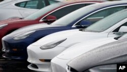 FILE - In this May 9, 2021, photo, a long row of unsold sedans sits at a Tesla dealership in Littleton, Colo. 
