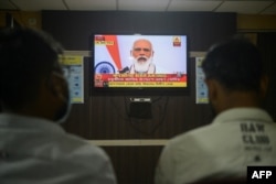 FILE - Journalists watch as India's Prime Minister Narendra Modi addresses the nation, at a journalist club in Siliguri, India, Oct. 20, 2020.