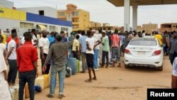 People gather to get fuel at a station, as clashes between the paramilitary Rapid Support Forces and the army continue, in south Khartoum locality, Sudan, April 30, 2023.