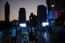 People wearing face masks walk on a street, amid the coronavirus disease (COVID-19) pandemic, in Shanghai, China, Nov. 13, 2020.