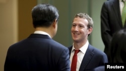 FILE - Facebook Chief Executive Mark Zuckerberg talks with Chinese President Xi Jinping during a gathering of CEOs and other executives at Microsoft's main campus in Redmond, Washington, Sept. 23, 2015.
