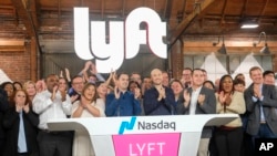 Lyft co-founders John Zimmer, center left, and Logan Green, center right, attend Lyft's IPO event in Los Angeles, California, March 29, 2019.