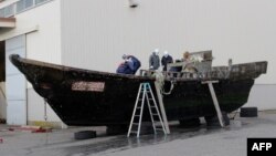 지난 2015년 11월 일본 서부 후쿠이현 후쿠이항에서 해안경비대원들이 북한에서 떠내려온 것으로 보이는 목조선을 조사하고 있다. (자료사진)