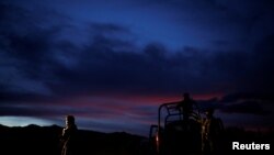 Soldiers assigned to the National Guard keep watch while escorting a caravan of vehicles with relatives and friends arriving for the funerals of slain members of the Mexican-American Mormon families, in Bavispe, Sonora state, Mexico November 6, 2019.