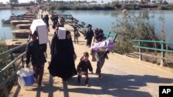 Displaced civilians from Ramadi and around the area cross the Bzebiz bridge as they leave their hometowns, heading towards Baghdad, Dec. 7, 2015. 