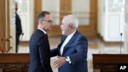 Iranian Foreign Minister Mohammad Javad Zarif, right, gestures to his German counterpart Heiko Maas at the end of their joint press conference in Tehran, Iran, June 10, 2019. 