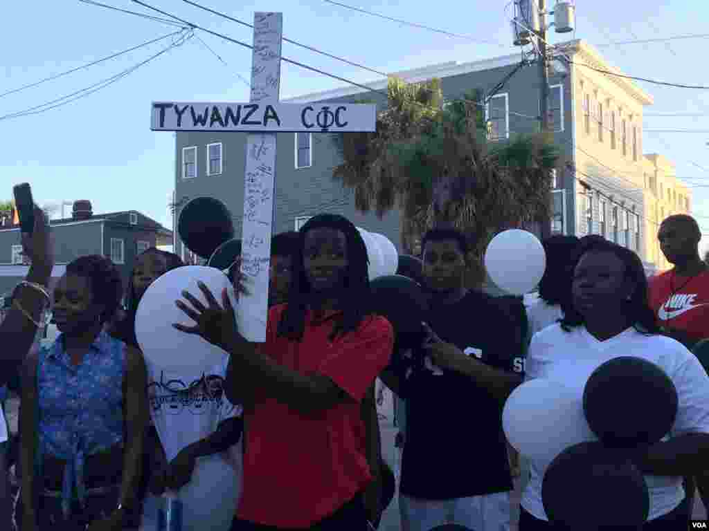 Mourners hold a cross for victims of the shooting at the Emanuel AME Church, Charleston, South Carolina, June 20, 2015. (Amanda Scott/VOA) 