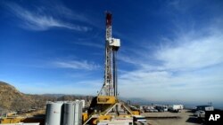 FILE - Crews work on stopping a gas leak at a relief well at the Aliso Canyon facility above the Porter Ranch area of Los Angeles, Dec. 9, 2015. The gas-storage facility had spewed methane for almost four months, driving thousands of families from their homes.