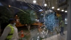 FILE - Saudi airport personnel are pictured behind shrapnel-riddled glass at Abha airport in the southwest of Saudi Arabia, August 31, 2021.