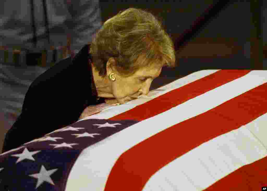 Former first lady Nancy Reagan kisses the casket of her husband former President Ronald Reagan prior to the removal of his remains from the Capitol Rotunda in Washington, June 11, 2004.