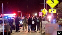 총격 사건이 발생한 미국 미시간 주립대 교정에 대응팀이 출동한 가운데 14일 새벽 학생들이 모여있다.