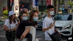 Members of a Chinese family wearing face masks walk in Bangkok, Thailand, Jan. 29, 2020. The Tourism Council of Thailand estimates the coronavirus outbreak will cost 50 billion bhat (U.S. $1,613,892) in lost tourism income for the Thai economy.