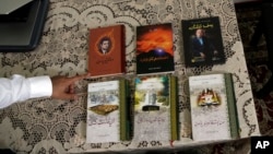 Kamalturk Yalqun displays material written by his father, Rozi, Thursday, April 18, 2019, in Philadelphia.