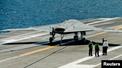 Pilotsiz uchadigan X-47B dronlari Jorj Bush harbiy kemasida qo'na oladi. 