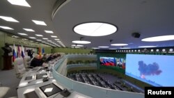 FILE - Russia's President Vladimir Putin (5th L) visits the National Defence Control Centre (NDCC) to oversee the test of a new Russian hypersonic missile system called Avangard, which can carry nuclear and conventional warheads, in Moscow, Dec. 26, 2018.