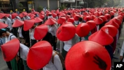 Guru sekolah anti kudeta dengan seragam dan topi tradisional Myanmar berpartisipasi dalam demonstrasi di Mandalay, Myanmar, 3 Maret 2021. (Foto: AP)