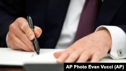 Доналд Трамп, во овалната соба во Белата куќа, ги потпишува првите извршни одредби, неколку часа после инаугурацијата на 20 јануари, 2025